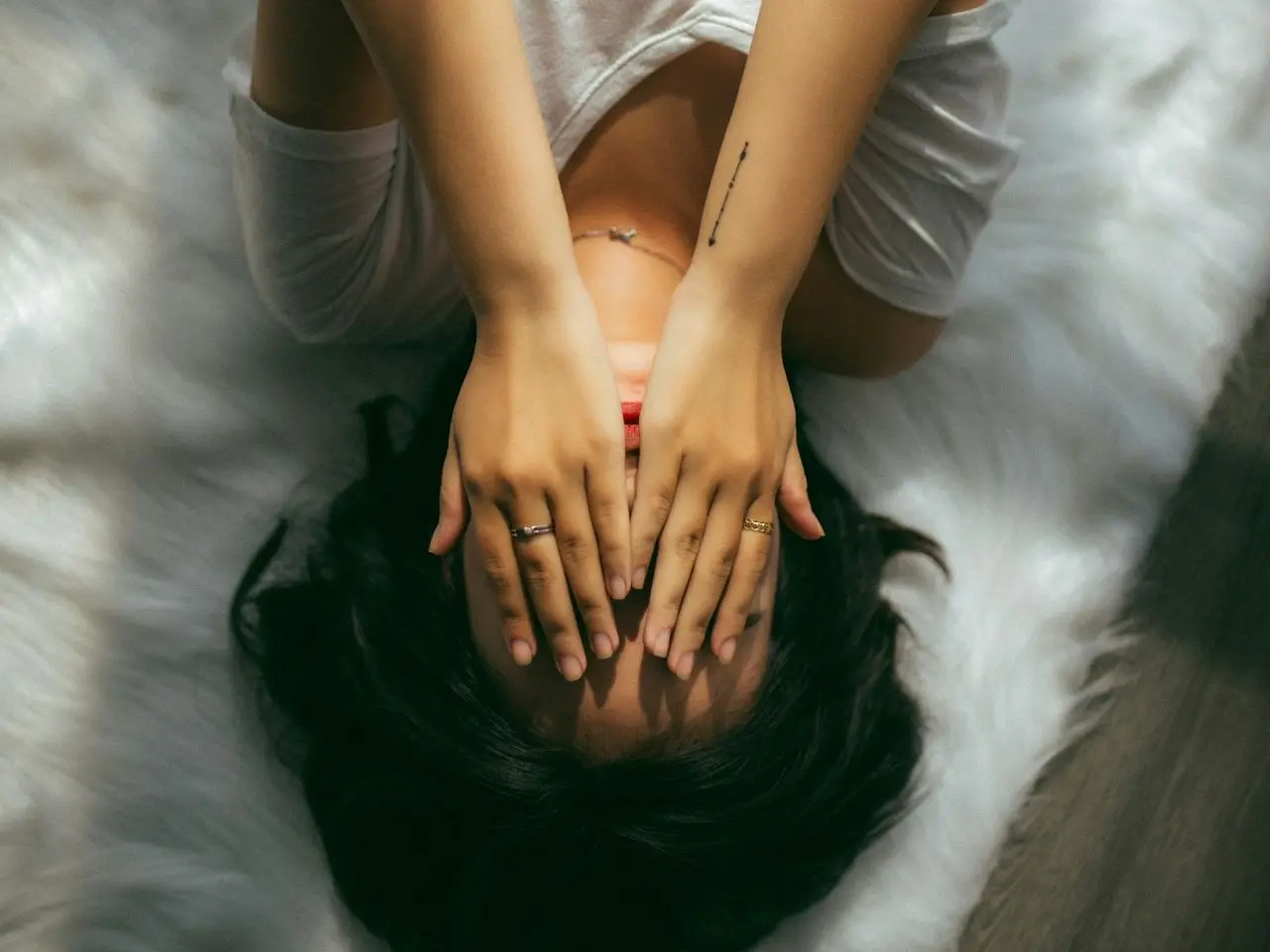 a woman holds her hands over her face